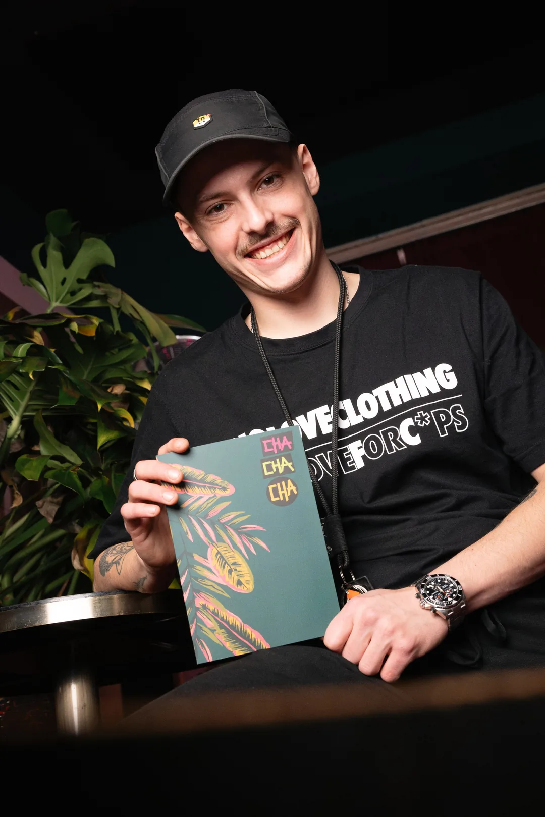 Der Barkeeper lacht und hält die Getränkekarte in der Hand