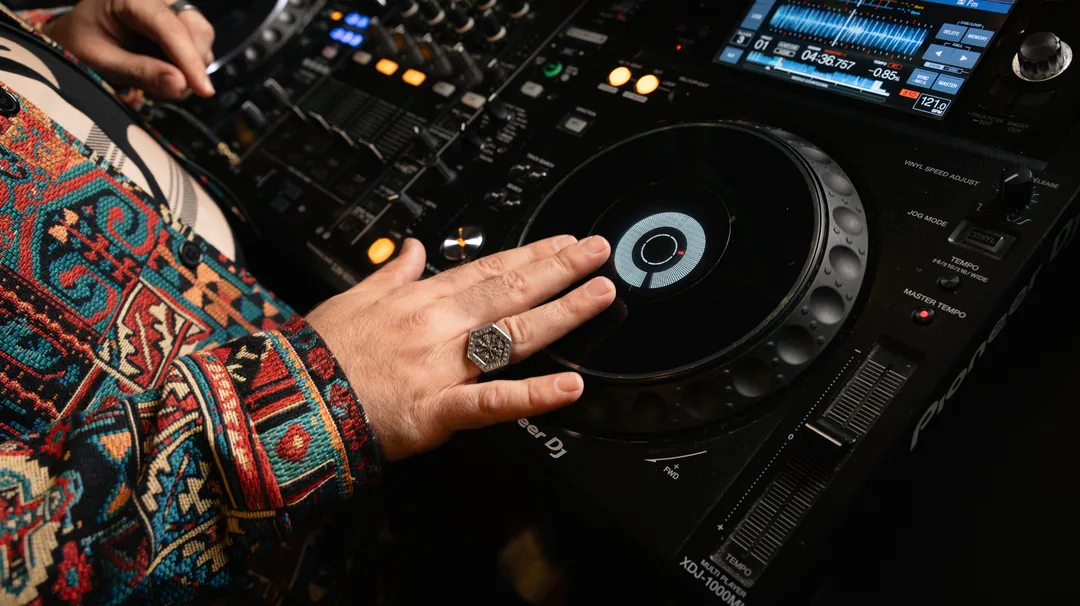 Eine Hand mit Ring am DJ-Pult