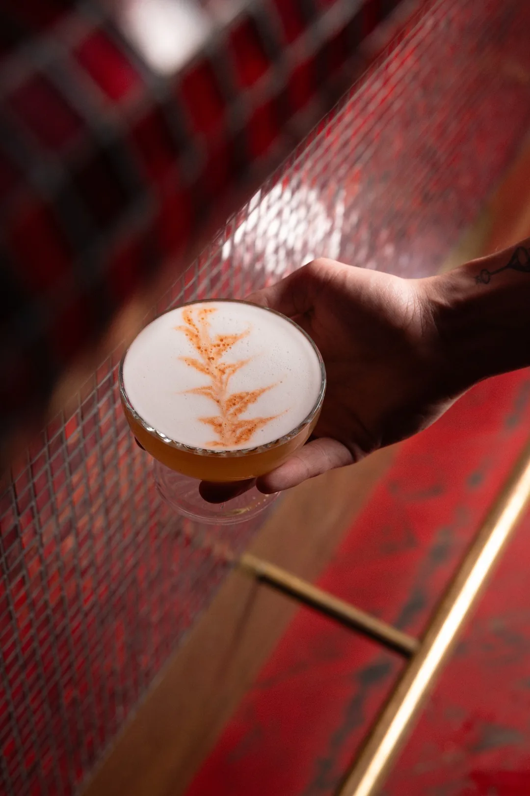Ein Sour mit einem Blatt aus Bitters auf dem Schaum
